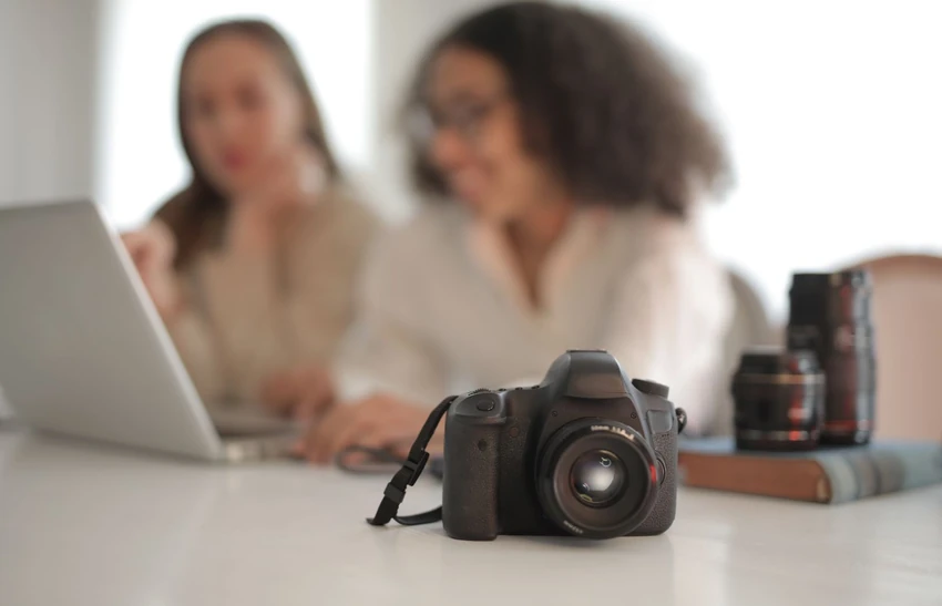 Camera with attached strap on a desk, illustrating the difference between a device and its accessory