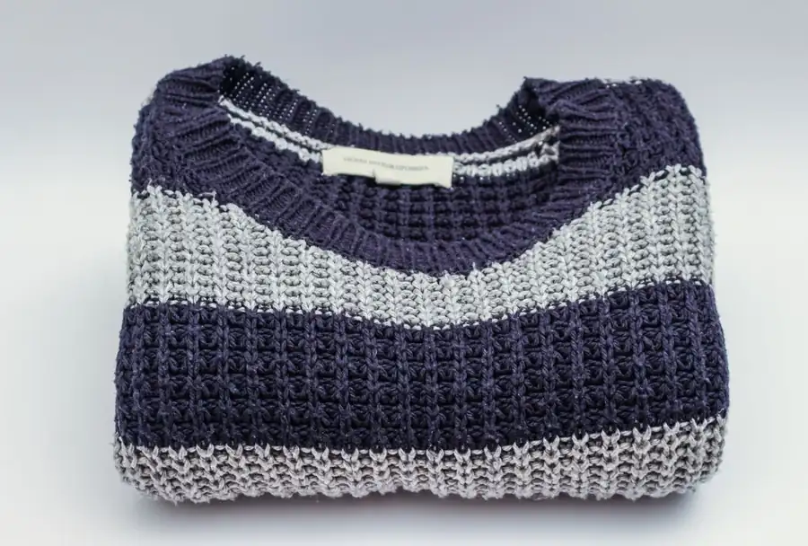 Folded striped knitwear with visible fabric texture for condition inspection