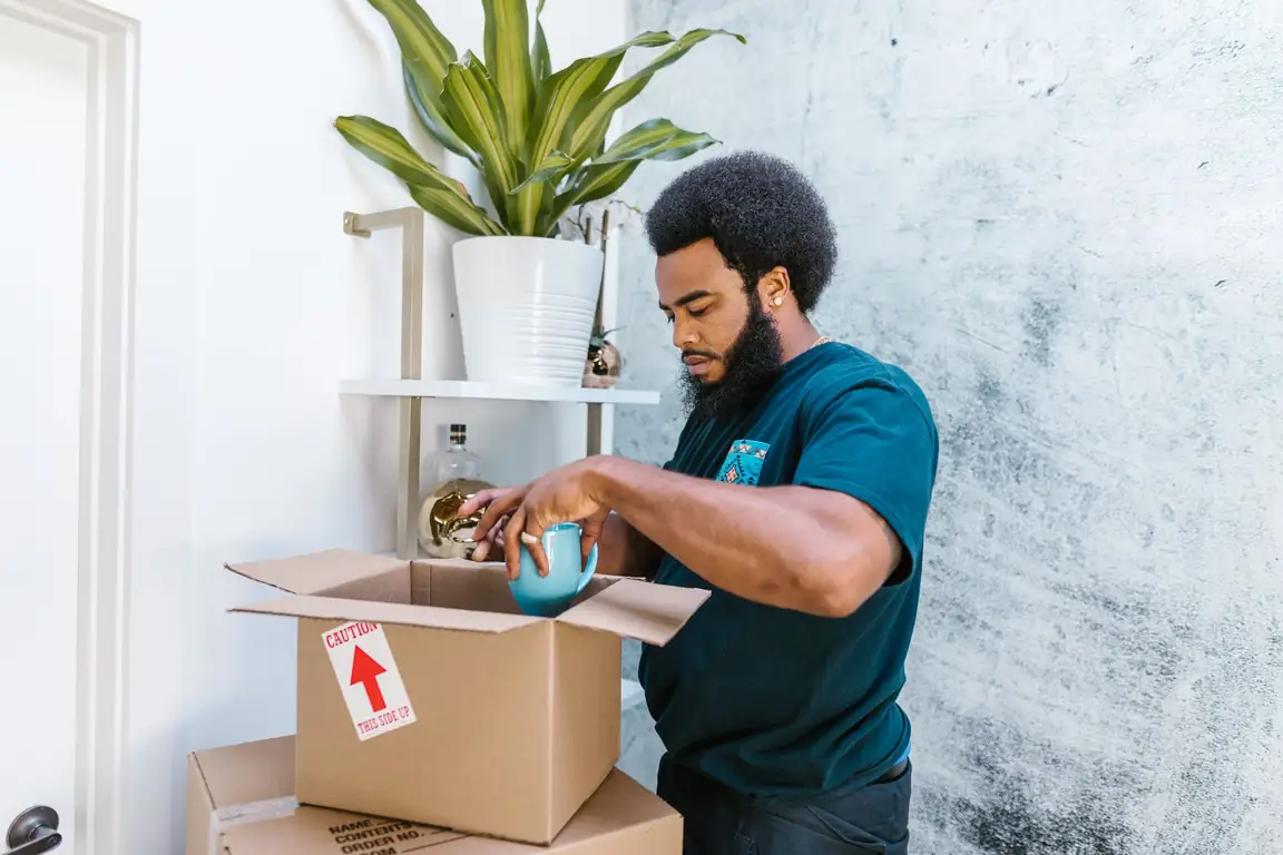 Seller packing a ceramic mug in a shipping box
